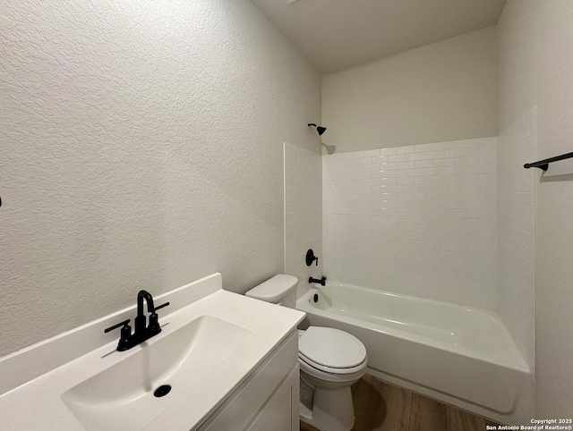 full bathroom with wood-type flooring, toilet, vanity, and shower / washtub combination