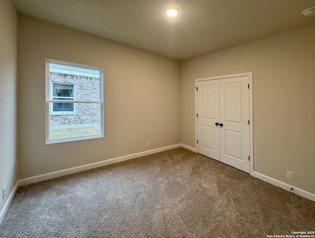 unfurnished bedroom featuring carpet flooring and a closet