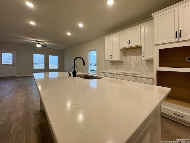 kitchen featuring light stone counters, sink, white cabinets, and ceiling fan