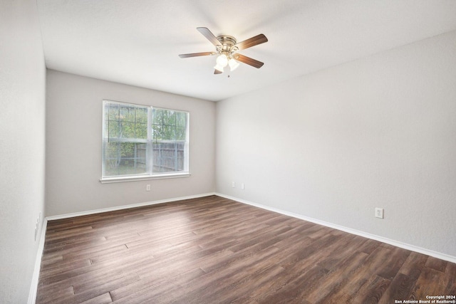 spare room with ceiling fan and dark wood-type flooring