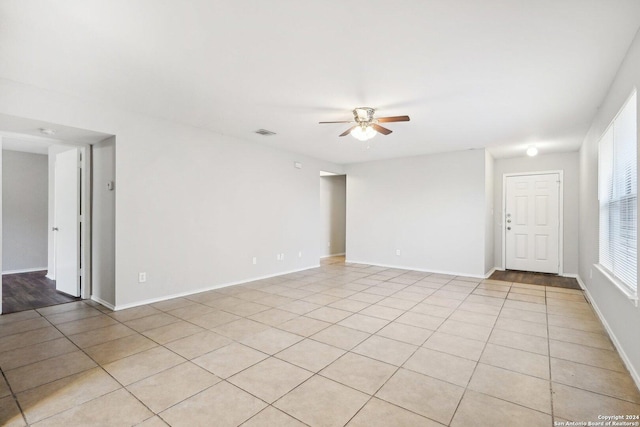 tiled empty room featuring ceiling fan