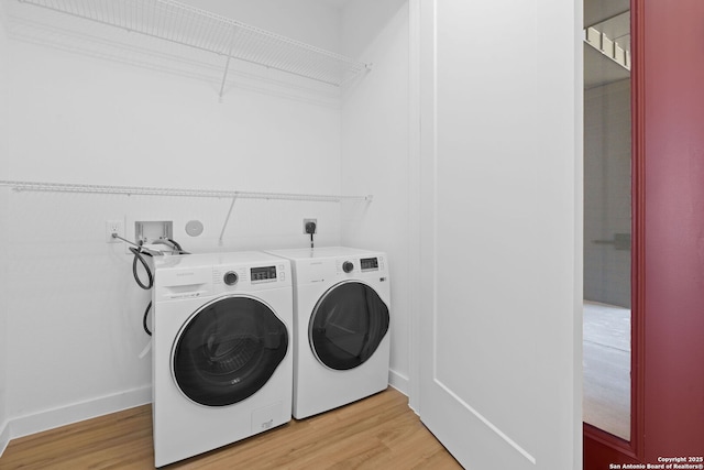 laundry room featuring light wood-type flooring and washer and clothes dryer