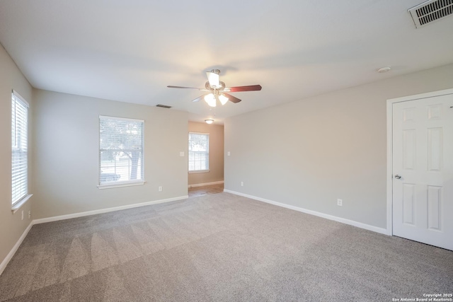 carpeted spare room featuring ceiling fan