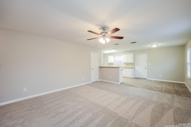 unfurnished living room featuring light colored carpet and ceiling fan