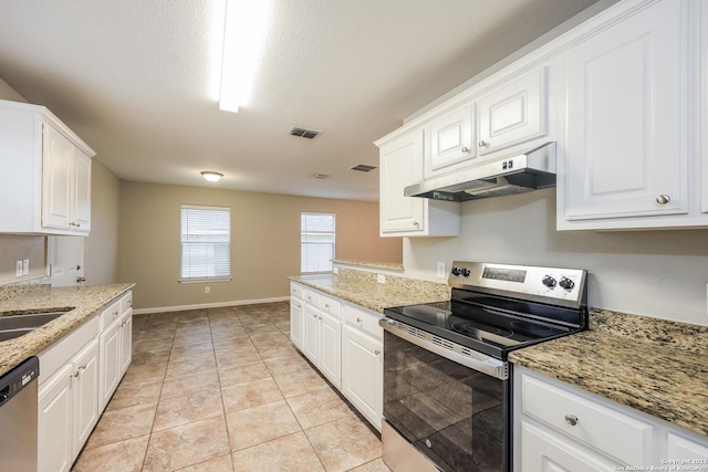 kitchen featuring light stone counters, white cabinetry, light tile patterned floors, and stainless steel appliances