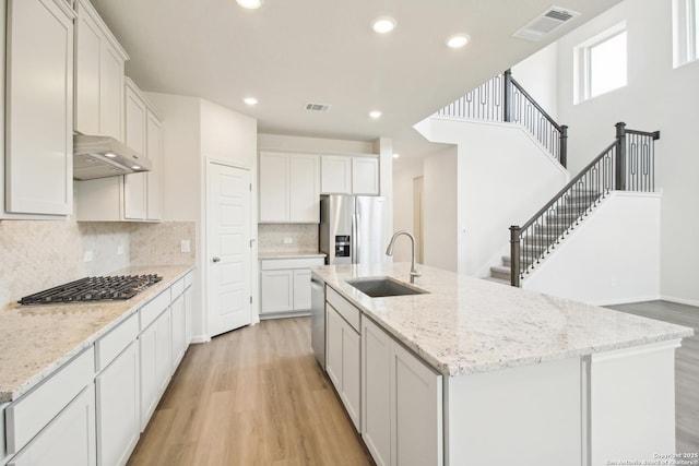 kitchen featuring sink, a kitchen island with sink, white cabinetry, and stainless steel appliances