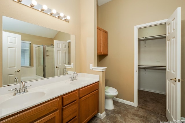 bathroom with toilet, a shower with door, and vanity