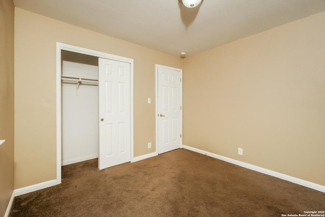 unfurnished bedroom with a closet and dark colored carpet