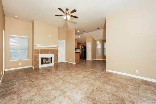 unfurnished living room featuring a tiled fireplace and ceiling fan