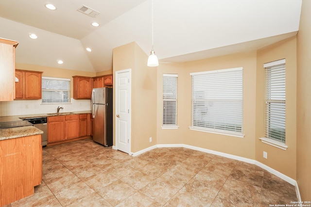 kitchen with tasteful backsplash, hanging light fixtures, sink, stainless steel appliances, and lofted ceiling