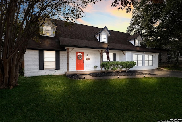 new england style home featuring a lawn