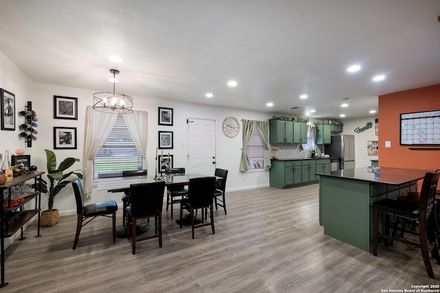 dining room featuring hardwood / wood-style floors, an inviting chandelier, and a textured ceiling