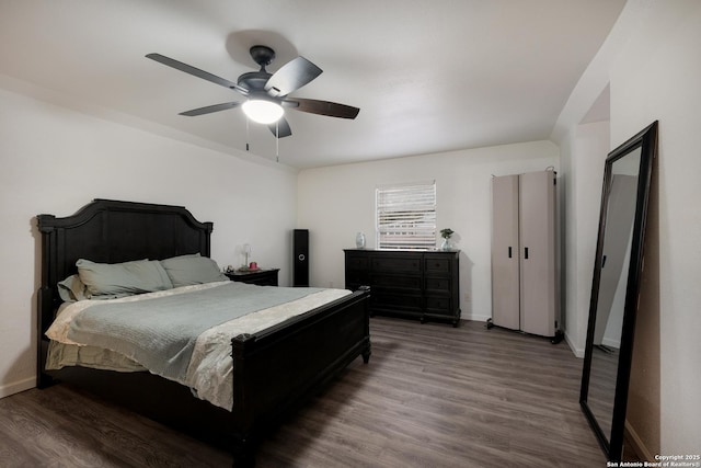 bedroom with ceiling fan and dark wood-type flooring