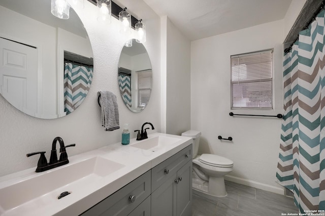 bathroom featuring toilet, vanity, and walk in shower