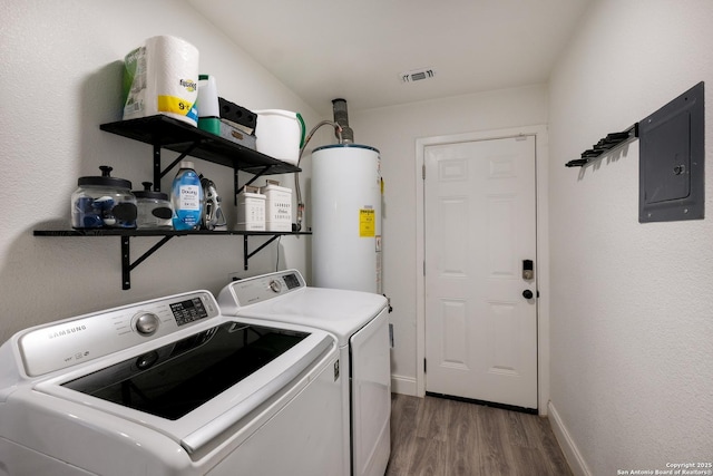 laundry room with electric panel, hardwood / wood-style flooring, washer and clothes dryer, and gas water heater