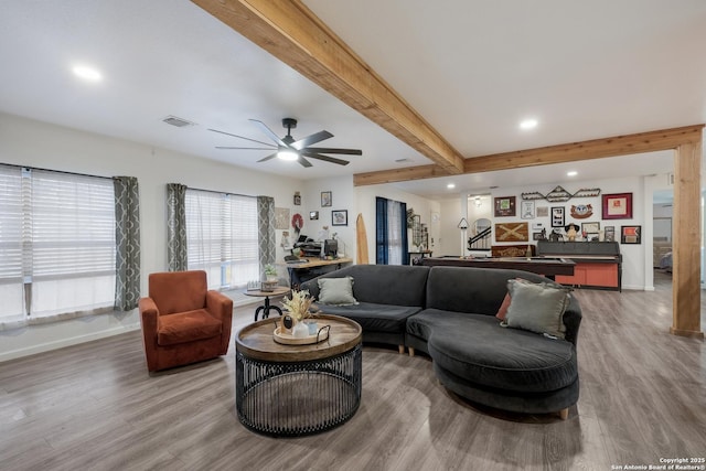 living room featuring hardwood / wood-style flooring, beamed ceiling, and ceiling fan