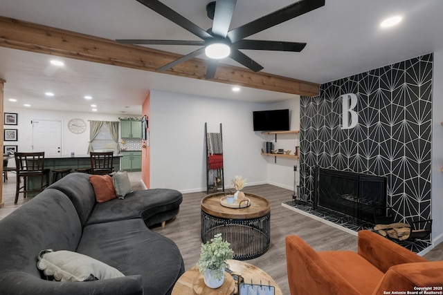 living room with a fireplace, hardwood / wood-style floors, beamed ceiling, and ceiling fan