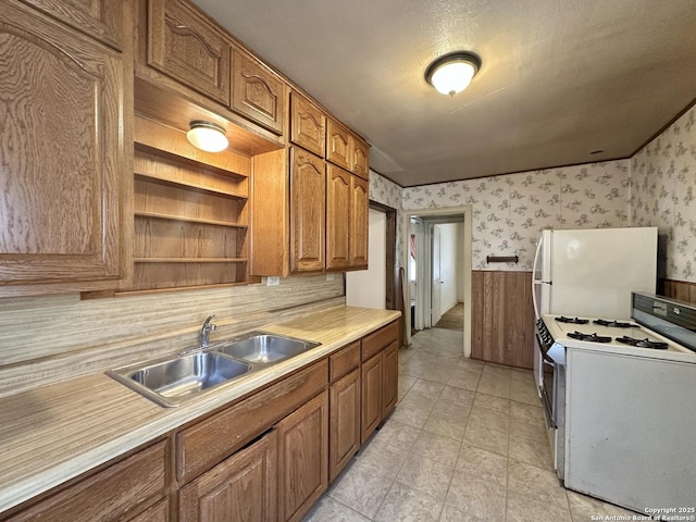 kitchen featuring sink, white appliances, and a textured ceiling