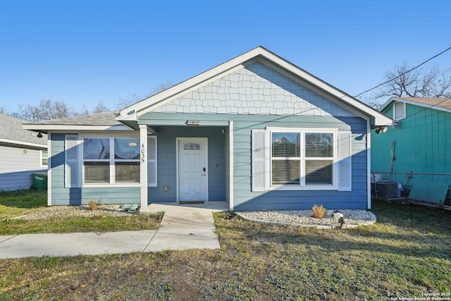 bungalow-style home featuring a front lawn and central air condition unit