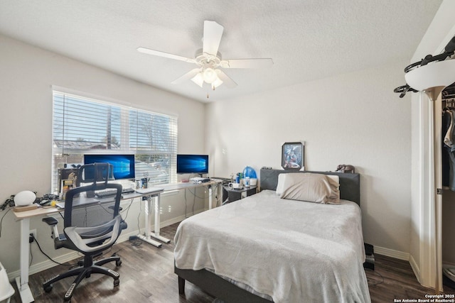 bedroom with dark wood-type flooring, a textured ceiling, and ceiling fan