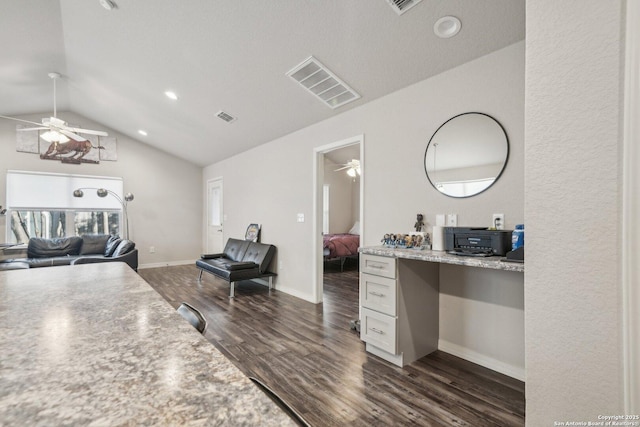 kitchen with ceiling fan, white cabinetry, dark hardwood / wood-style floors, lofted ceiling, and built in desk