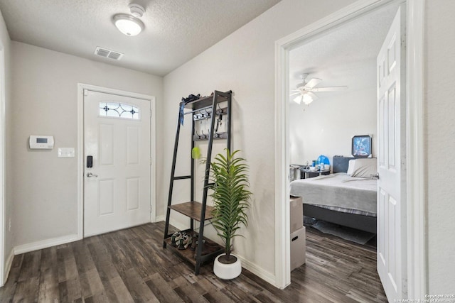 entrance foyer featuring ceiling fan, dark hardwood / wood-style floors, and a textured ceiling