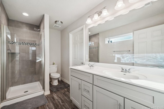 bathroom with hardwood / wood-style flooring, toilet, an enclosed shower, and vanity