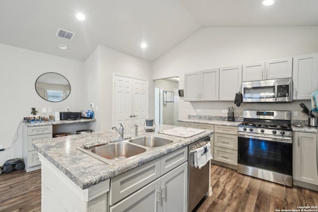 kitchen with a kitchen island with sink, sink, dark hardwood / wood-style flooring, stainless steel appliances, and lofted ceiling