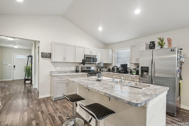 kitchen featuring a center island with sink, white cabinets, a breakfast bar, and stainless steel appliances