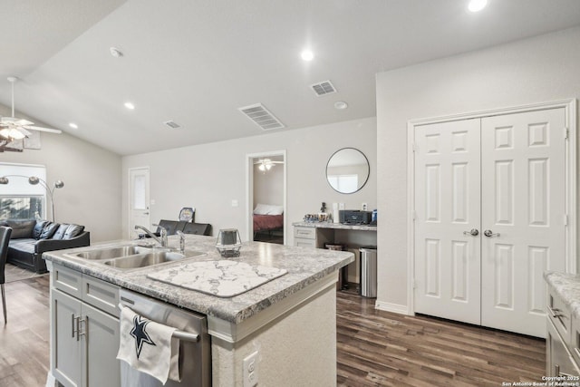 kitchen with sink, a kitchen island with sink, vaulted ceiling, ceiling fan, and stainless steel dishwasher