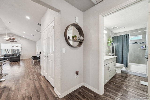 hallway featuring dark wood-type flooring and lofted ceiling