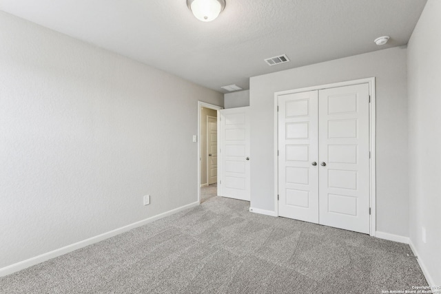 11559 Cottage Pt, San Antonio, TX 78254 - unfurnished bedroom featuring light colored carpet, a closet, and a textured ceiling
