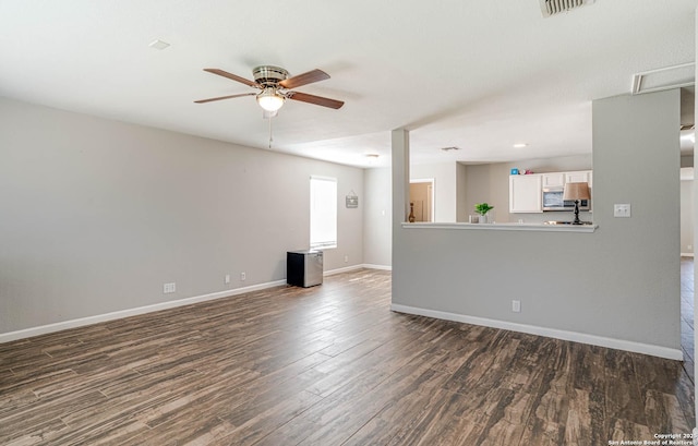 unfurnished living room with ceiling fan and dark wood-type flooring