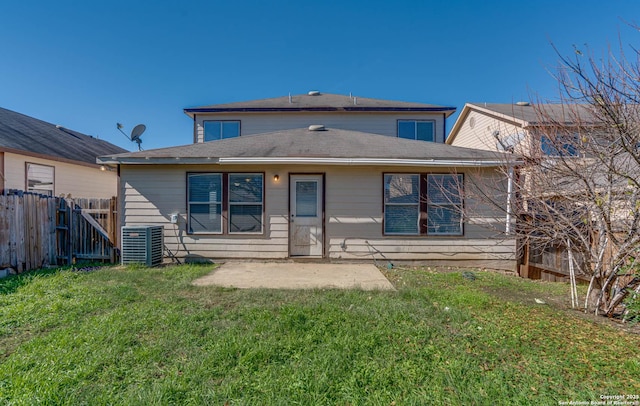 rear view of property featuring a lawn, central AC unit, and a patio