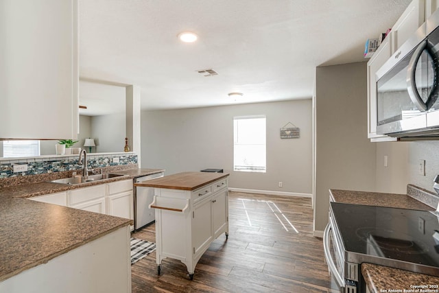 kitchen featuring a center island, white cabinetry, sink, dark wood-type flooring, and stainless steel appliances