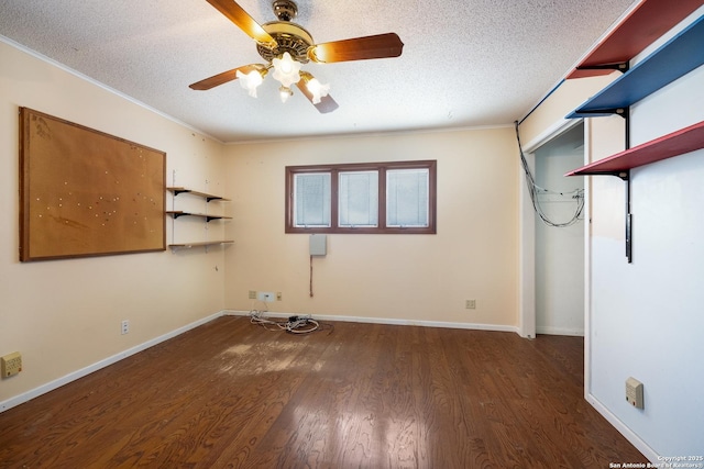 empty room featuring dark wood-type flooring, ceiling fan, ornamental molding, and a textured ceiling