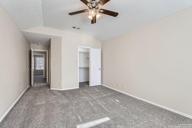 unfurnished bedroom featuring ceiling fan, a textured ceiling, dark colored carpet, and vaulted ceiling