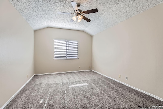 spare room with ceiling fan, a textured ceiling, vaulted ceiling, and carpet