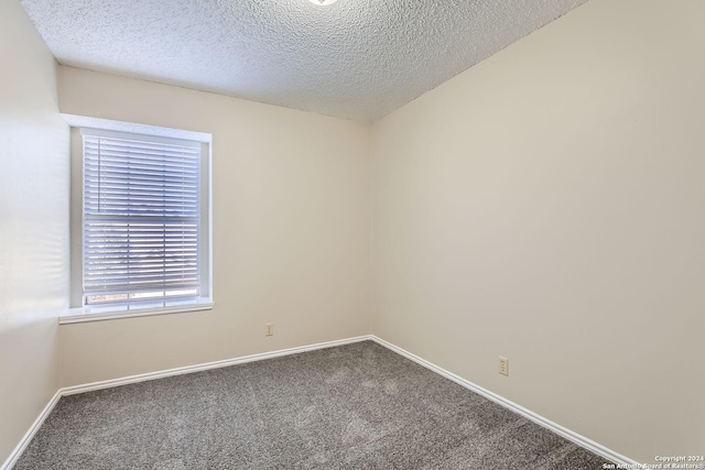 empty room with a textured ceiling and carpet