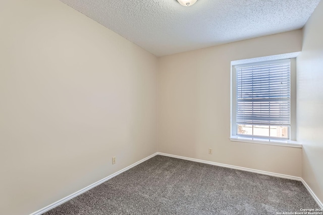 carpeted spare room featuring a textured ceiling