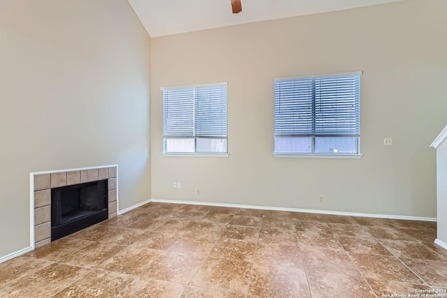 unfurnished living room featuring ceiling fan and a tiled fireplace