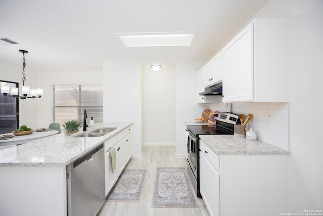 kitchen with white cabinetry, stainless steel appliances, decorative backsplash, sink, and hanging light fixtures