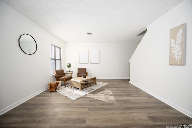 sitting room featuring dark hardwood / wood-style floors and a textured ceiling