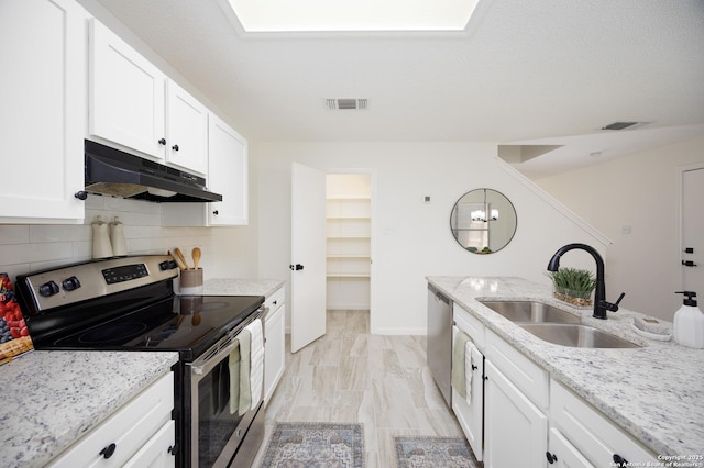 kitchen with white cabinetry, decorative backsplash, sink, stainless steel appliances, and light stone counters