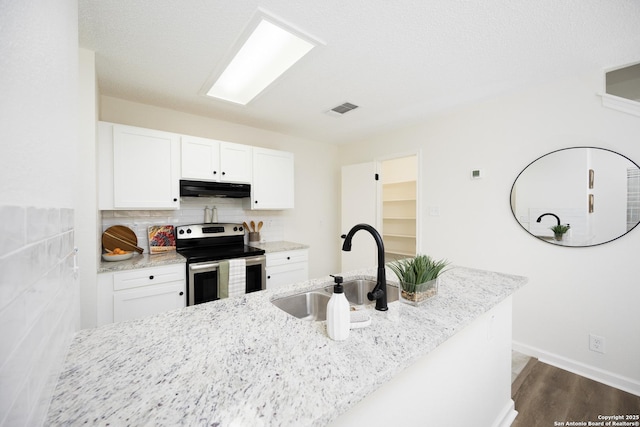 kitchen featuring light stone countertops, sink, white cabinetry, and stainless steel range with electric cooktop