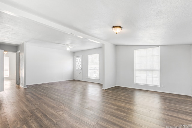 unfurnished room featuring ceiling fan, dark hardwood / wood-style flooring, a textured ceiling, and lofted ceiling