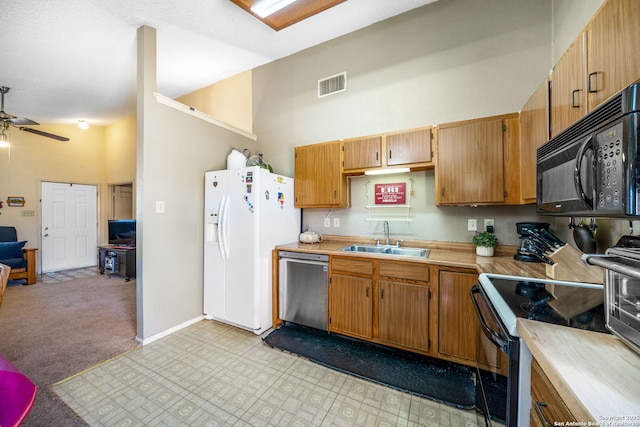 kitchen featuring light carpet, stainless steel dishwasher, sink, a high ceiling, and white fridge with ice dispenser