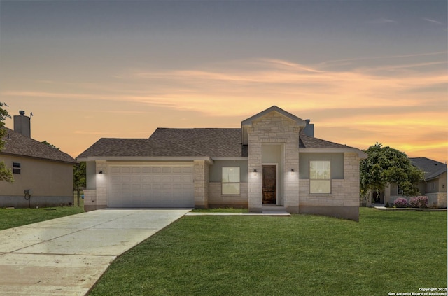 view of front of property with a garage and a lawn