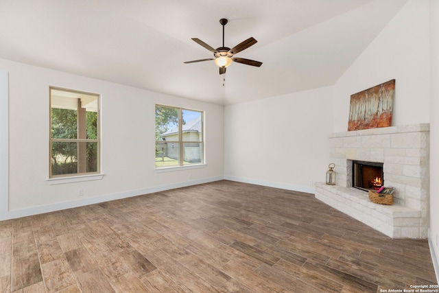 unfurnished living room with a fireplace, hardwood / wood-style flooring, a healthy amount of sunlight, and lofted ceiling