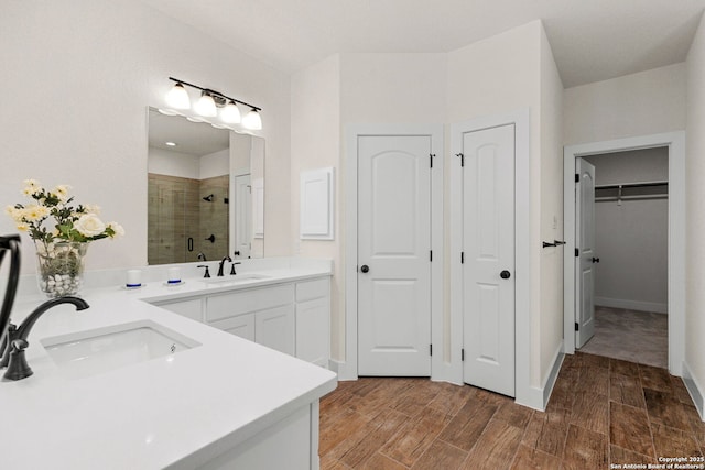 bathroom with a shower with door and vanity